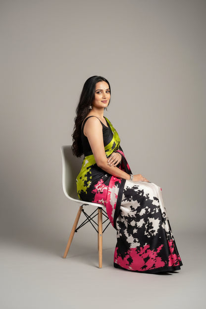Woman wearing a colorful saree with a gradient design on a plain background