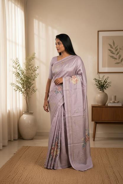 Woman in a light purple saree standing in a room with decor elements.