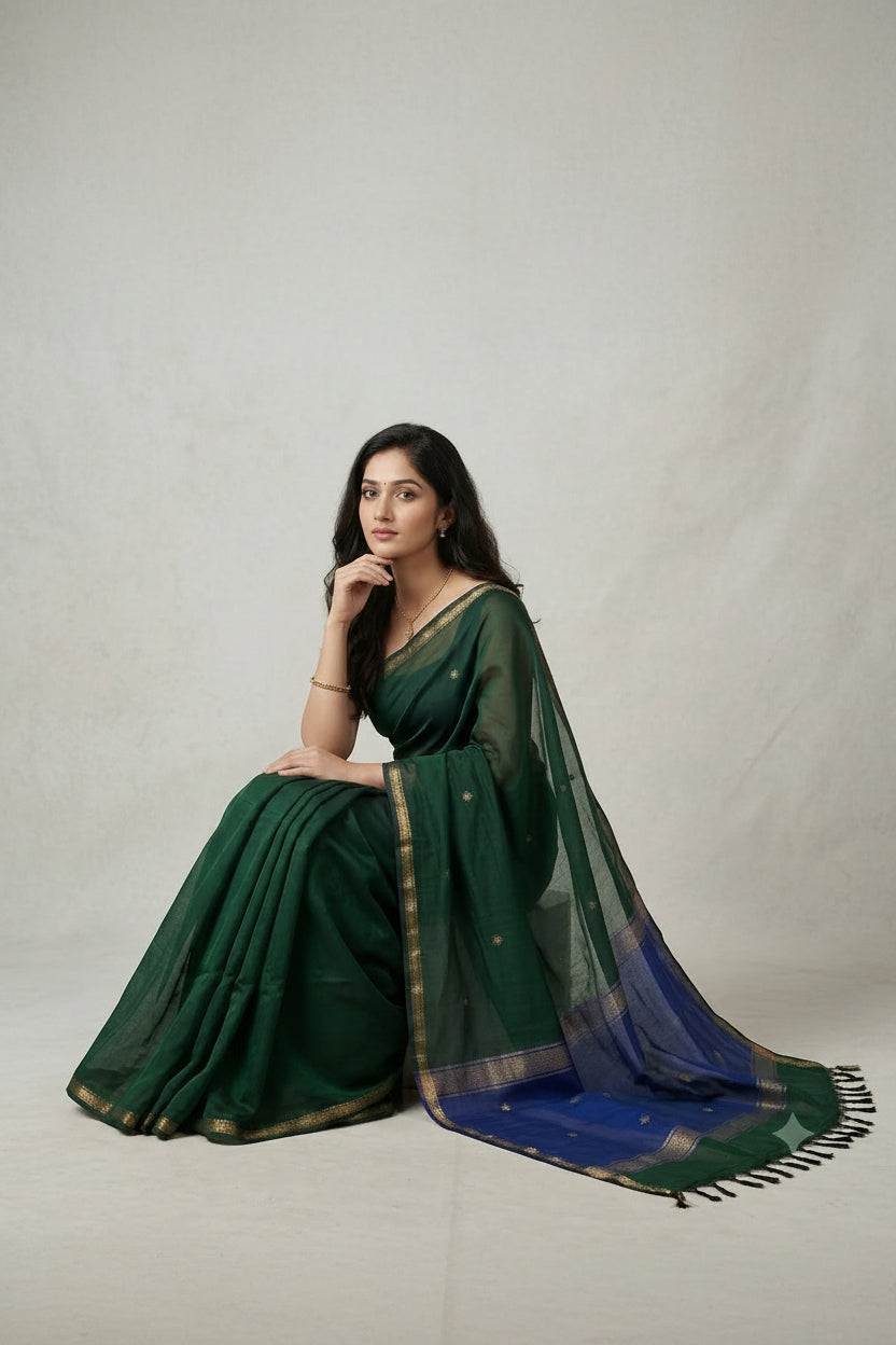 Woman wearing a green saree with a blue border on a light gray background