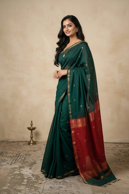 Woman wearing a green and red saree with a plain background