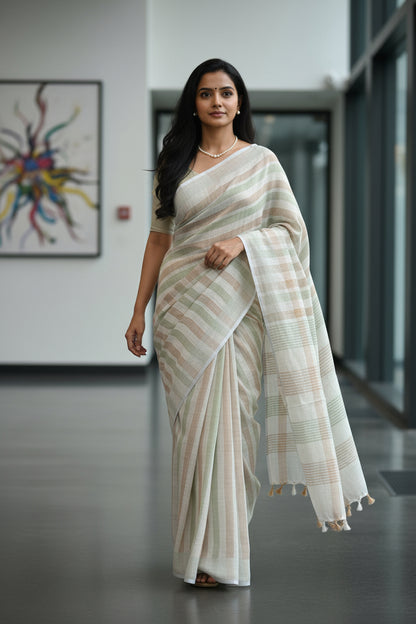 Woman in a white saree standing in a modern indoor setting with abstract art in the background.