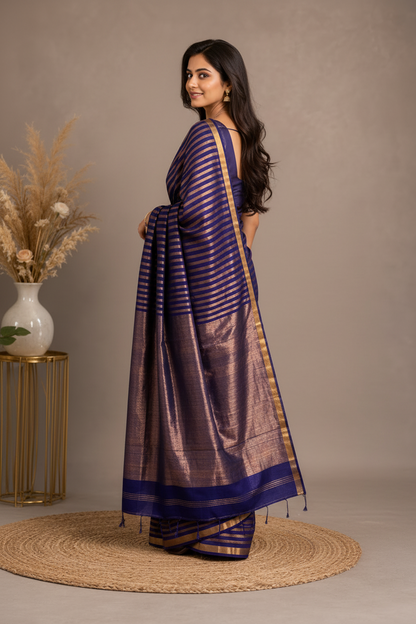 Woman wearing a blue and gold saree with a neutral background