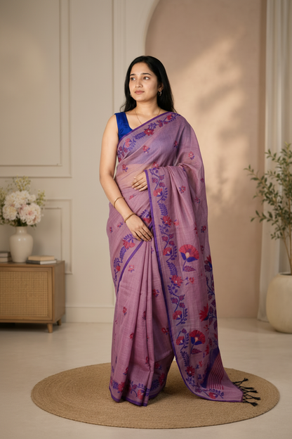 Woman wearing a purple saree with floral patterns in a room with a neutral color scheme.