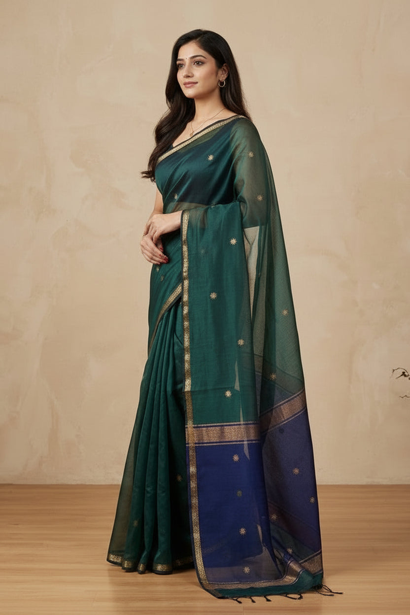 Woman wearing a green and blue saree with a beige background