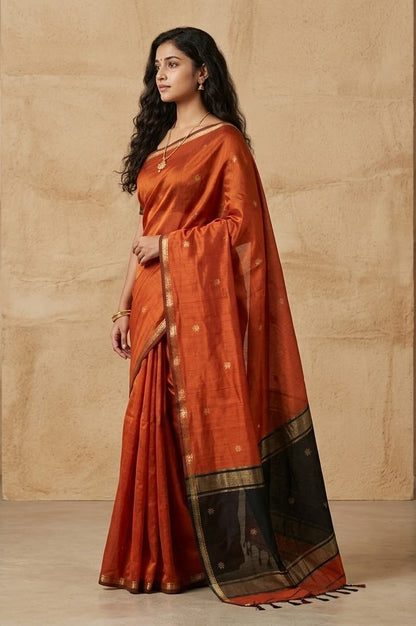 Woman wearing a traditional orange saree with a beige background