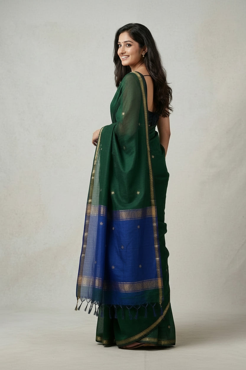 Woman wearing a green saree with a blue blouse on a plain background